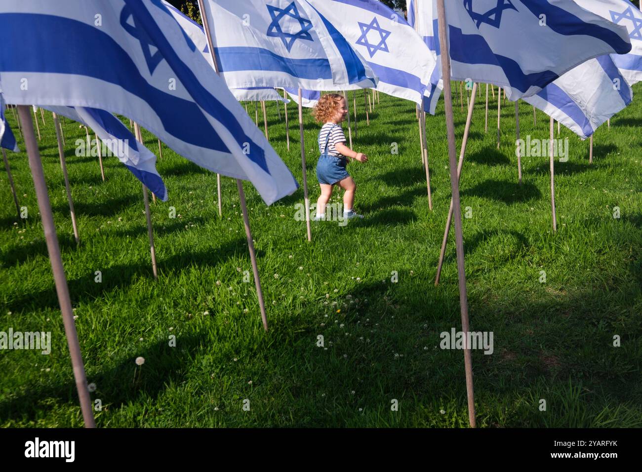 Commemorating the war in Israel. A boy walks by Israeli flags. Beverly Hills, Los Angeles, California, United States of America Stock Photo
