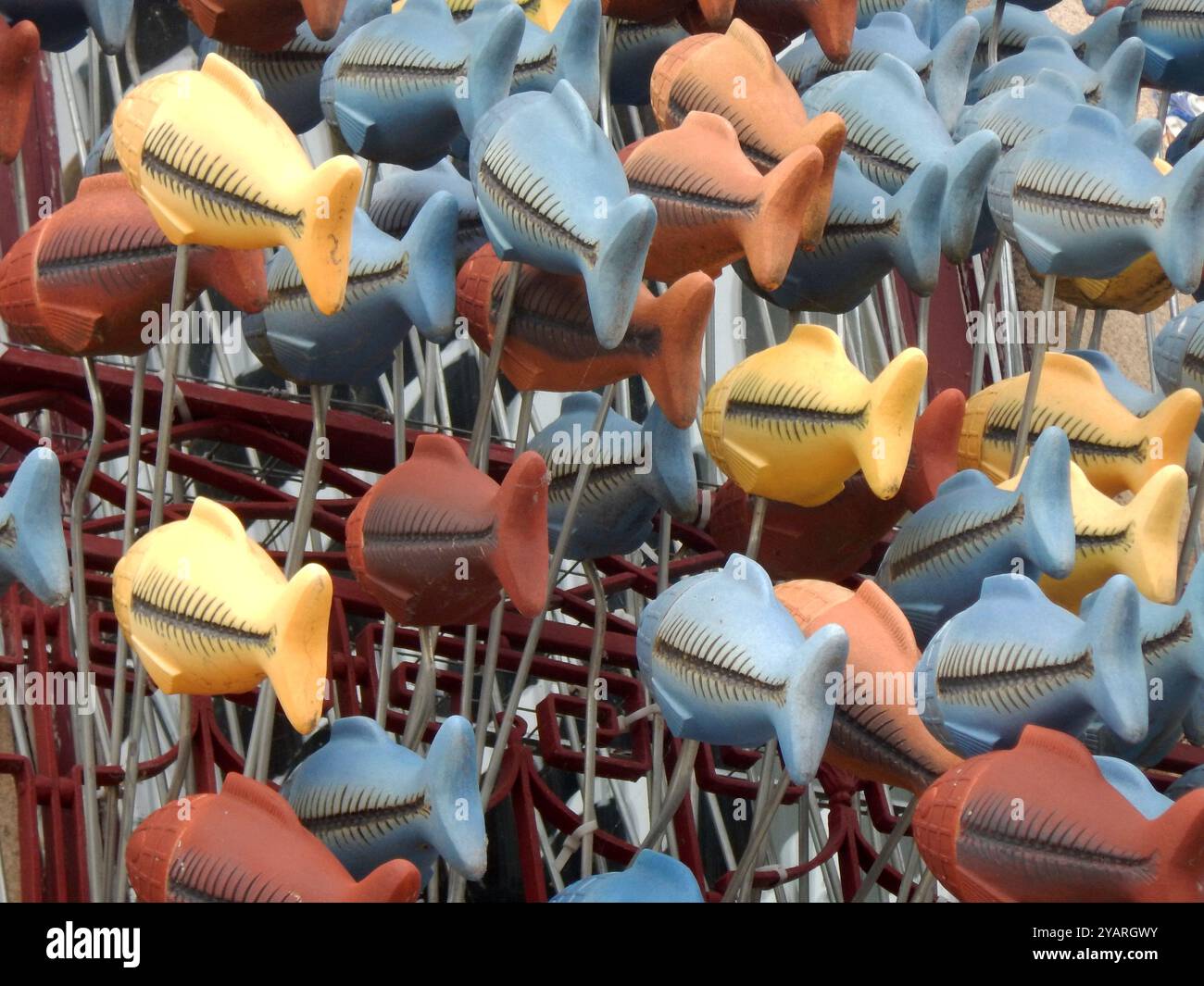 Hanging goldfish of different colors running away in the same direction Stock Photo