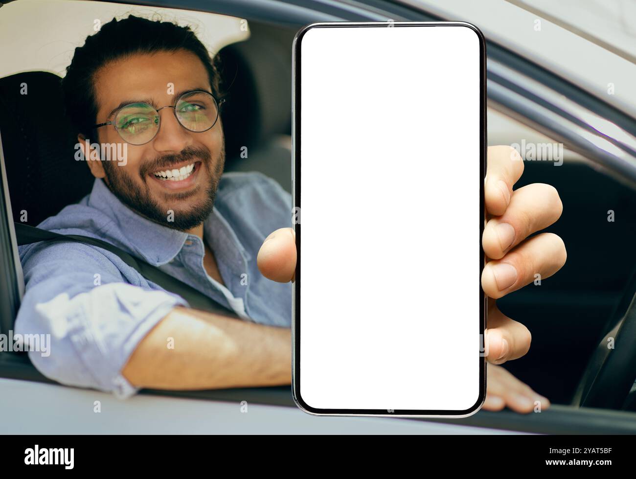 Happy indian driver using showing smartphone with empty screen Stock Photo