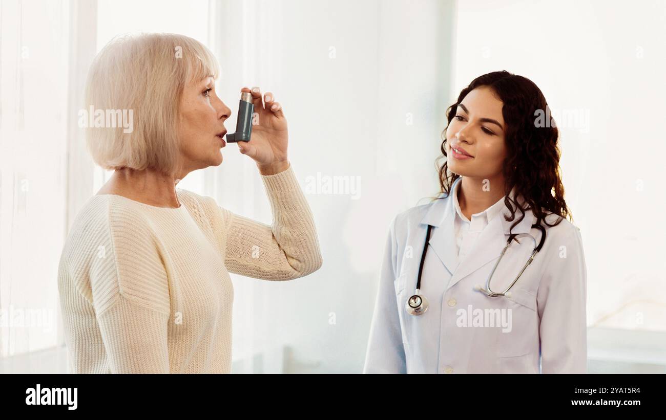 Physician examining mature woman using blue asthma inhaler Stock Photo