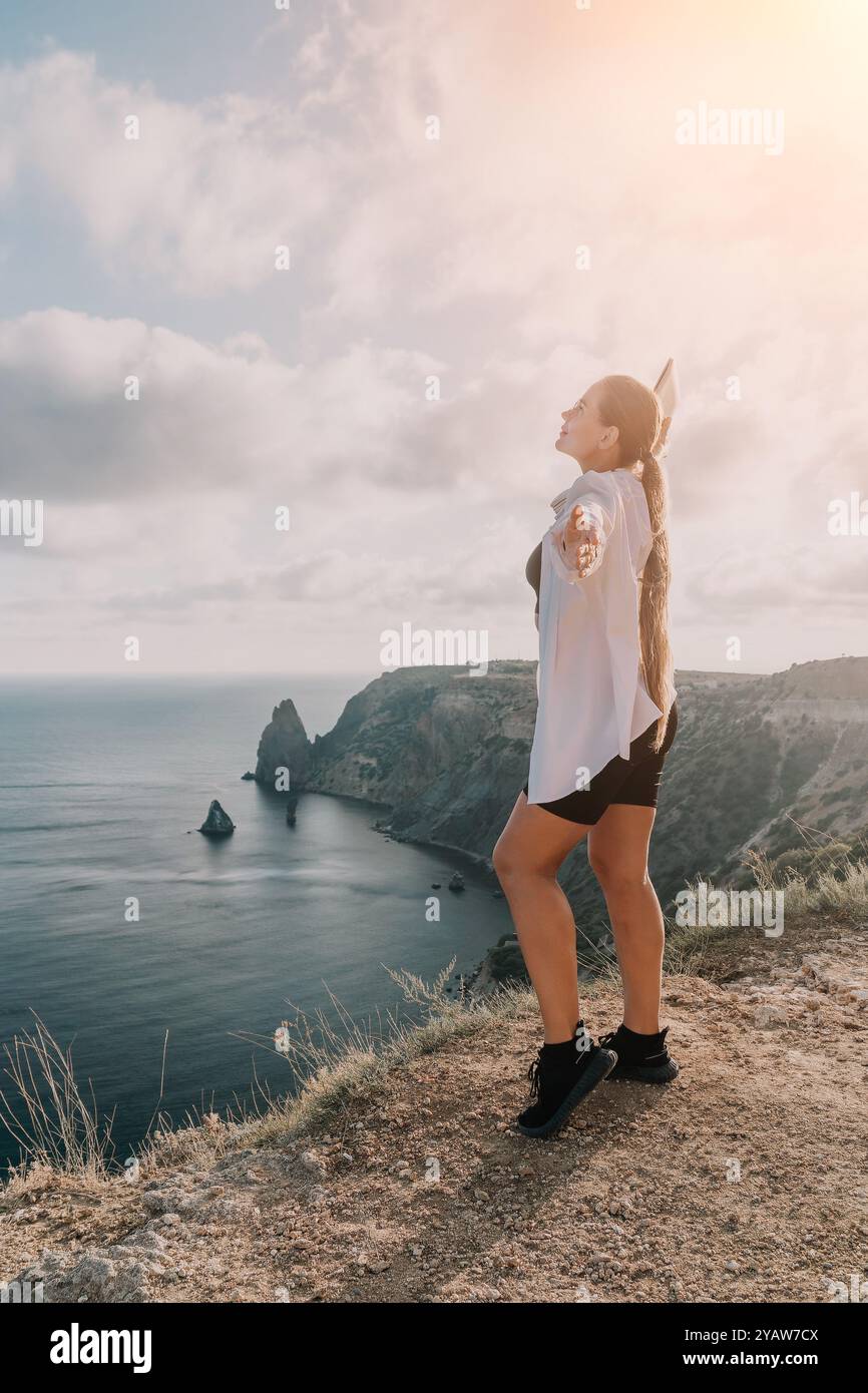 Woman Cliff Ocean - A woman stands on a cliff overlooking the ocean ...