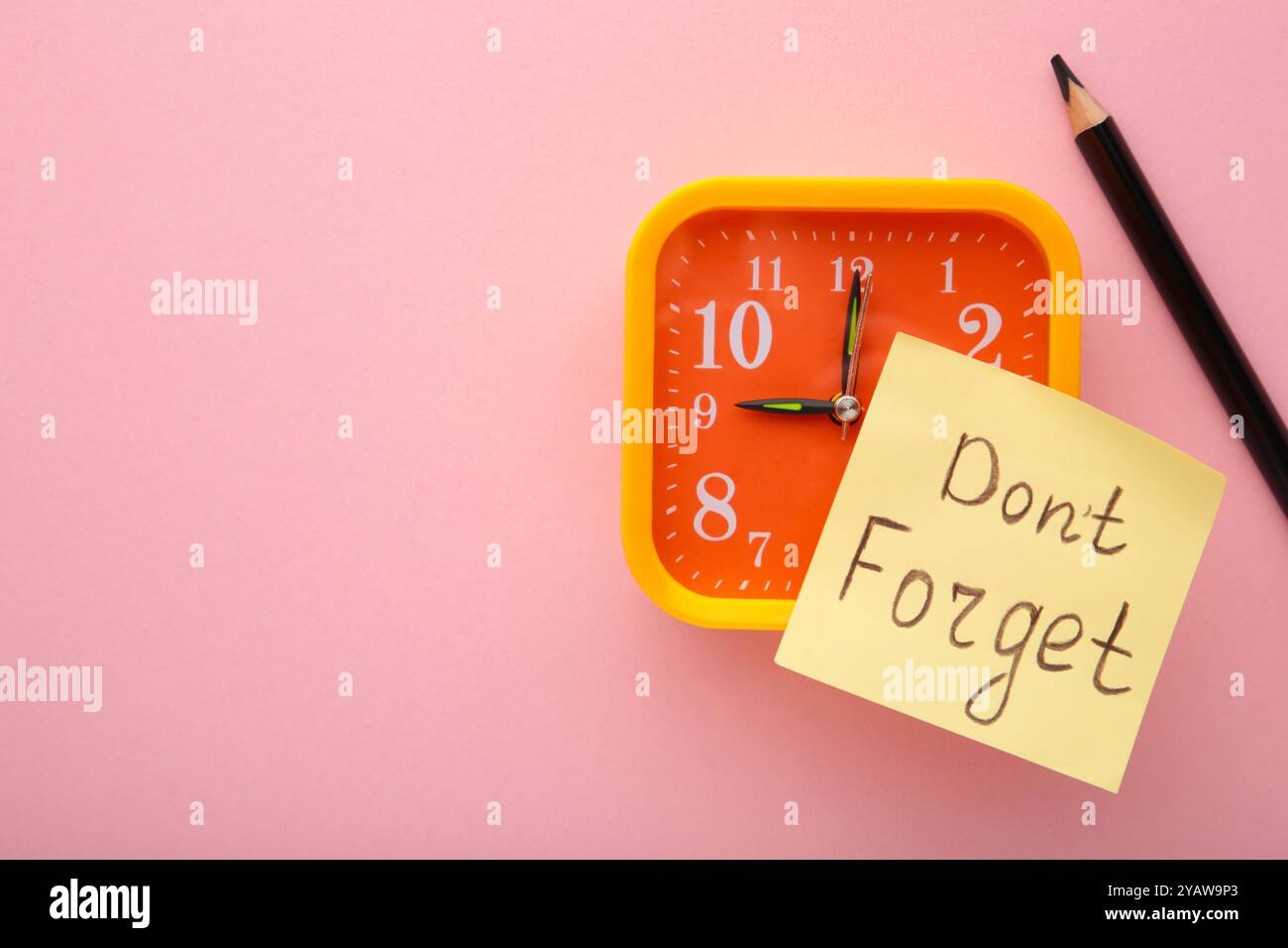 Alarm clock and reminder note with phrase Don't forget on pink ...