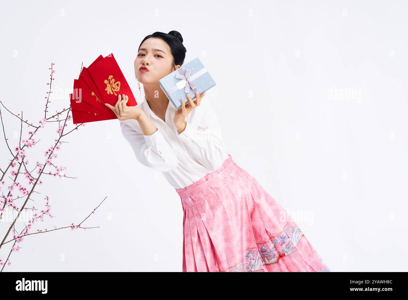A young Chinese woman holding red envelopes and gift boxes Stock Photo