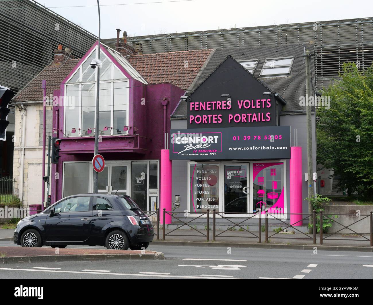 France. Montigny les Cormeilles. Val d'Oise. Commercial area. "Confort Baie" shop.  BANLIEUE. BATIMENT. BUILDING. MODERNE. MODERN. NEUF. NEW. COMMERCE. TRADE. ENTREPRISE. ENSEIGNE. Commercial zone. Shopping area. MAGASIN. CHAINE DE MAGASINS. BOUTIQUE. BUREAU. OFFICE. FENETRES. VOLETS. PORTES. PORTAILS. VOITURE. VEHICULE. FIAT 500 Stock Photo