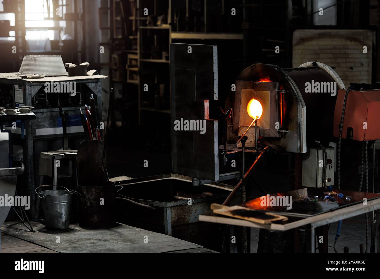 Industrial glassblowing furnaces actively running in glassware factory ...