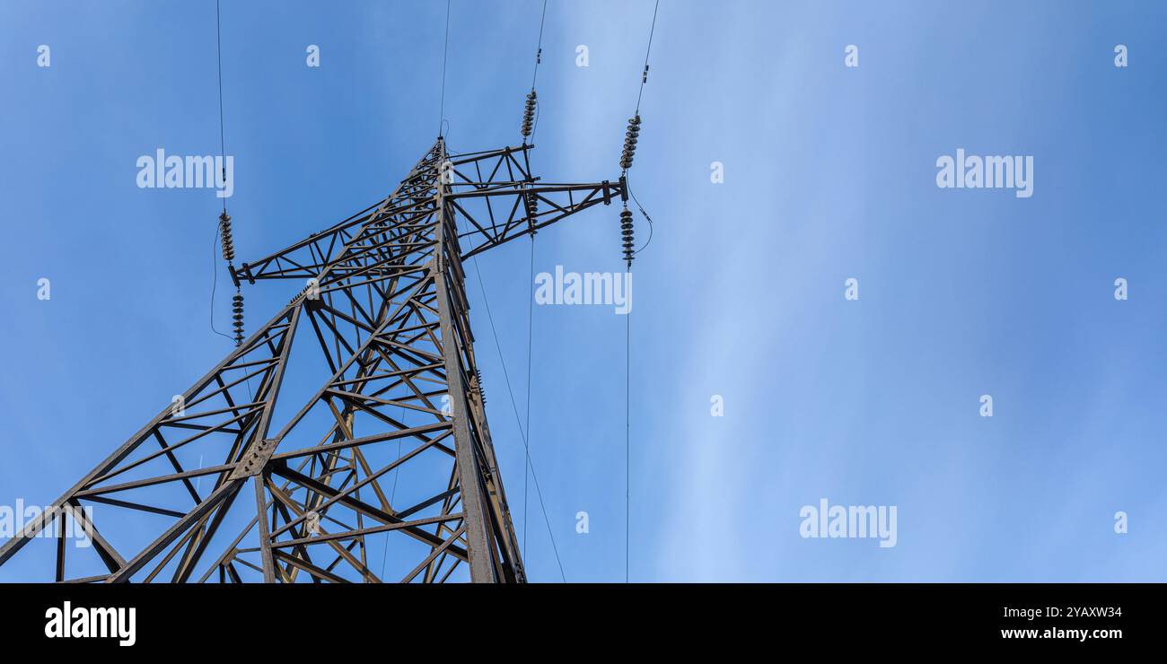 Tower of high voltage transmission stands tall against blue sky with ...