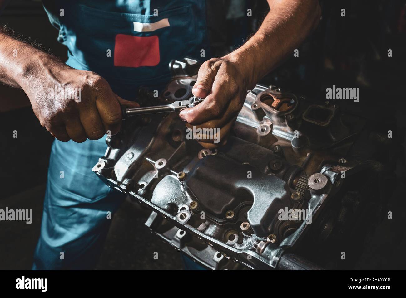 Auto mechanic repairing an engine in a dark garage Stock Photo - Alamy
