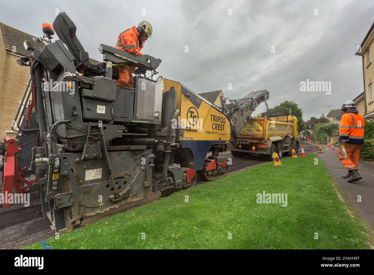 A team of workman operating heavy machinery to resurface a residential road in Wiltshire. Stock Photo