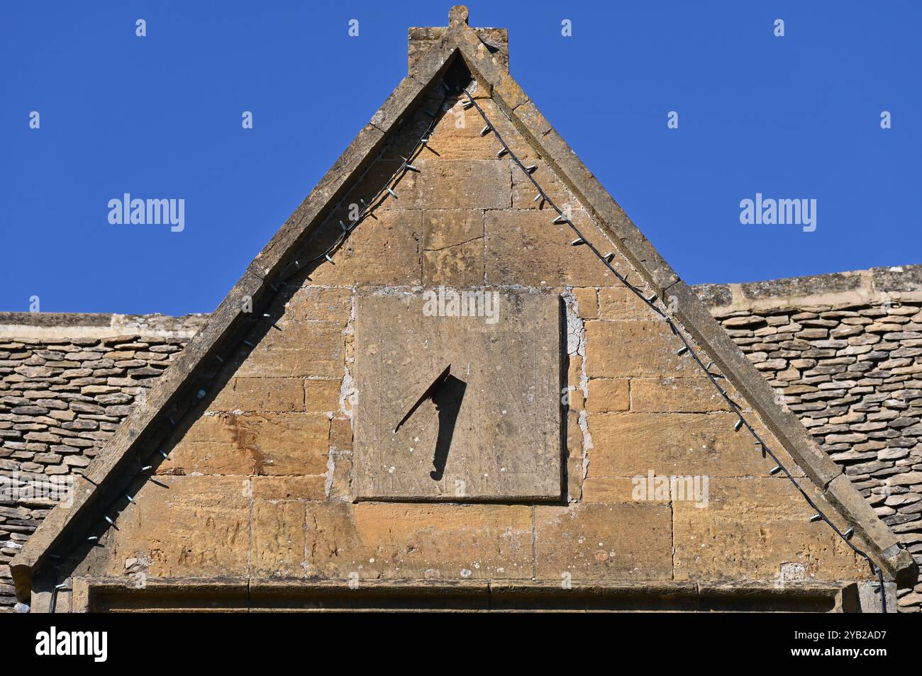 Sundial on the front facade of a house in the Gloucestershire town of Chipping Campden Stock Photo