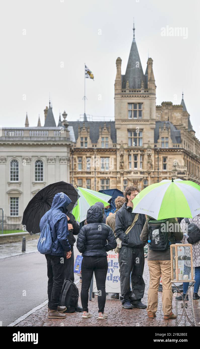 A tourist group congregate at King' Parade on a rainy day, with ...