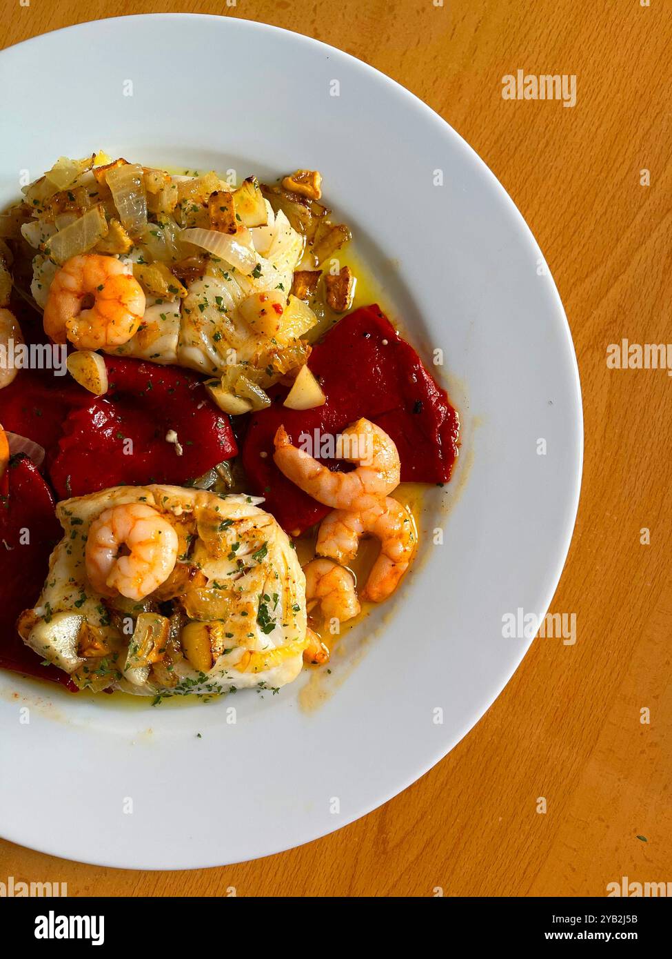 Hake loin with prawns, Piquillo peppers, garlic, onion and oregano. Spain. - Smartphone Captured Stock Image