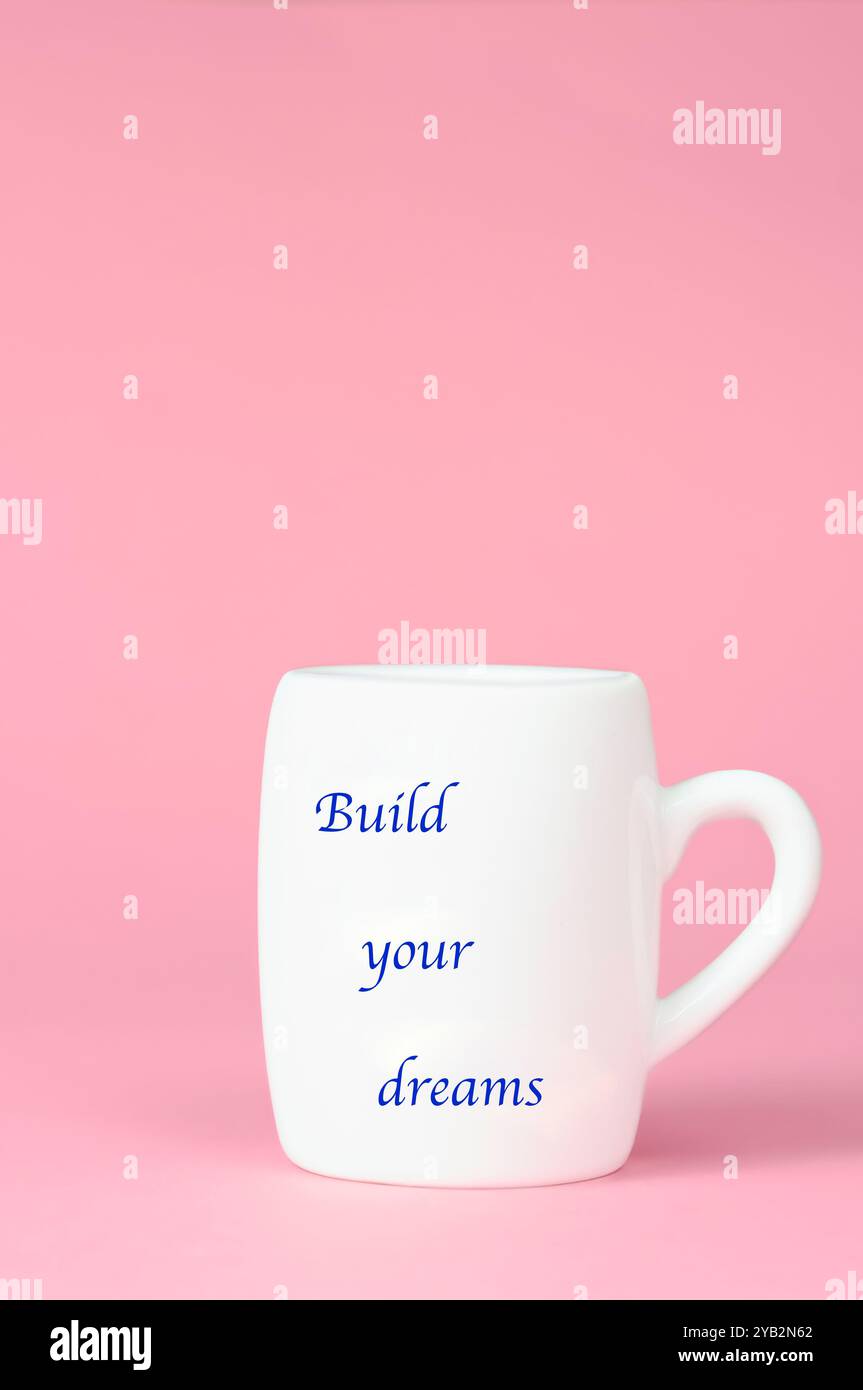 A mug with the written phrase: build your dreams. Stock Photo
