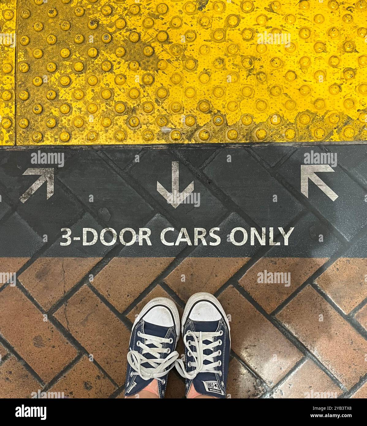 Platform marking for 3 door cars only with feet in converse shoes Stock ...