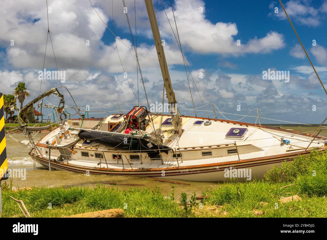 Texas City, Texas, USA - A boat wreak caused by a previous storm lists at waters edge along the gulf coast. Stock Photo