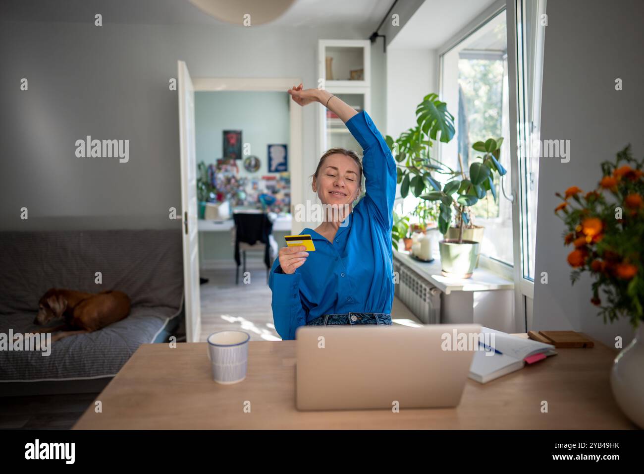 Happy woman stretching with pleasure enjoying convenient app for online booking internet shopping. Stock Photo