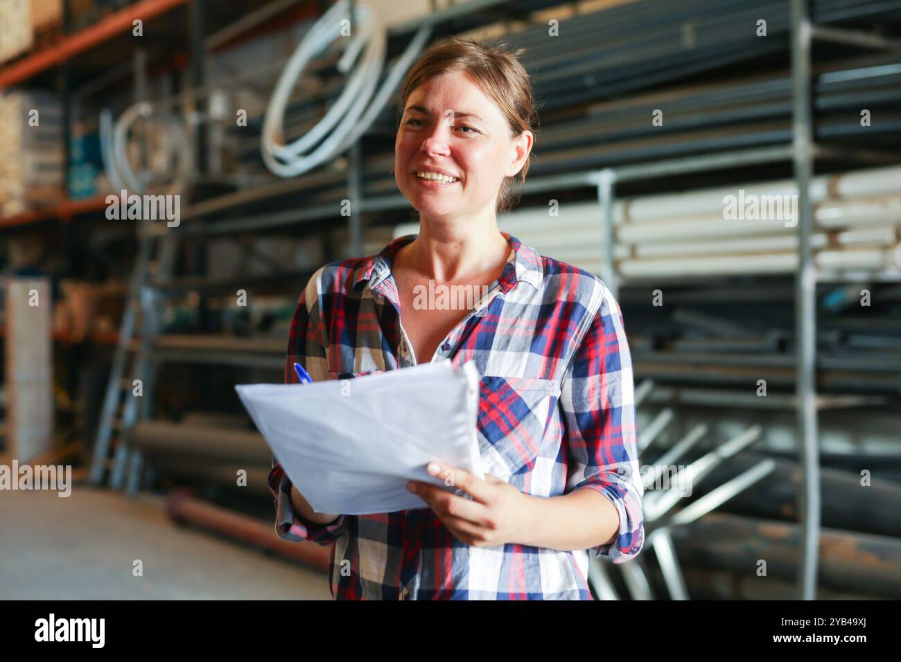 Joyful woman inspecting warehouse Stock Photo