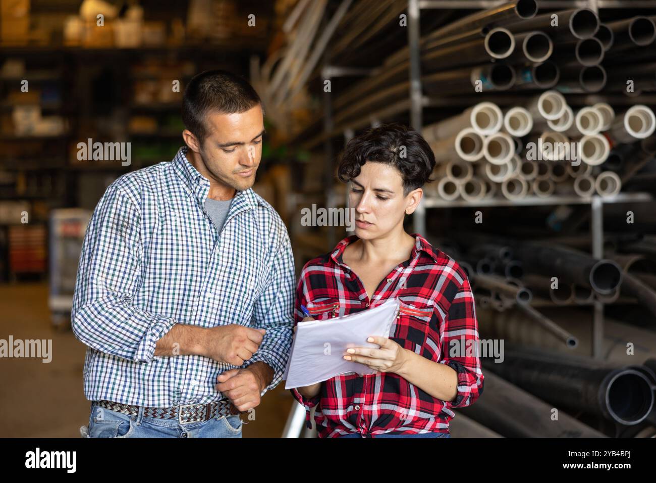 Man and woman verifying check list in warehouse Stock Photo - Alamy