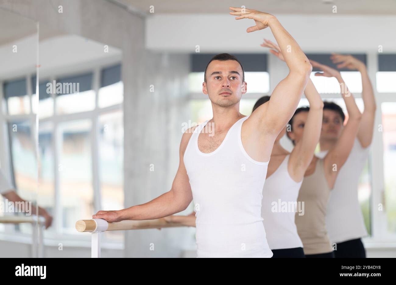 Man learning third position at barre at group ballet session Stock ...