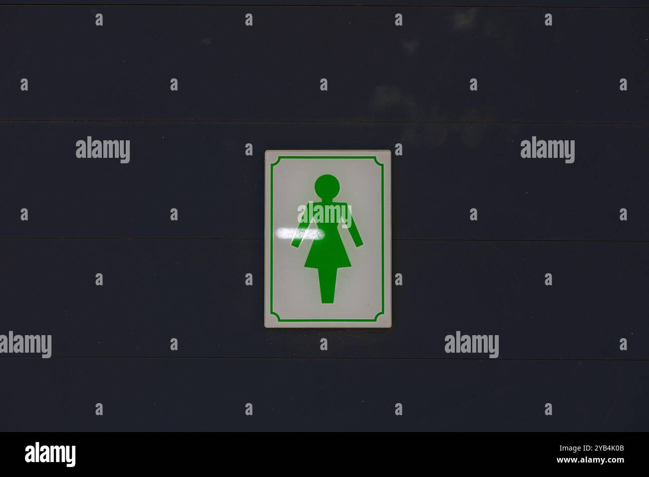 A bright green sign clearly designates the women's restroom, featuring ...