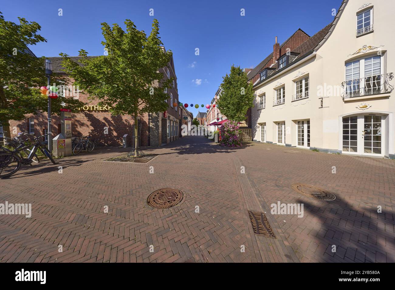 High street with general buildings and trees under a blue sky in the ...