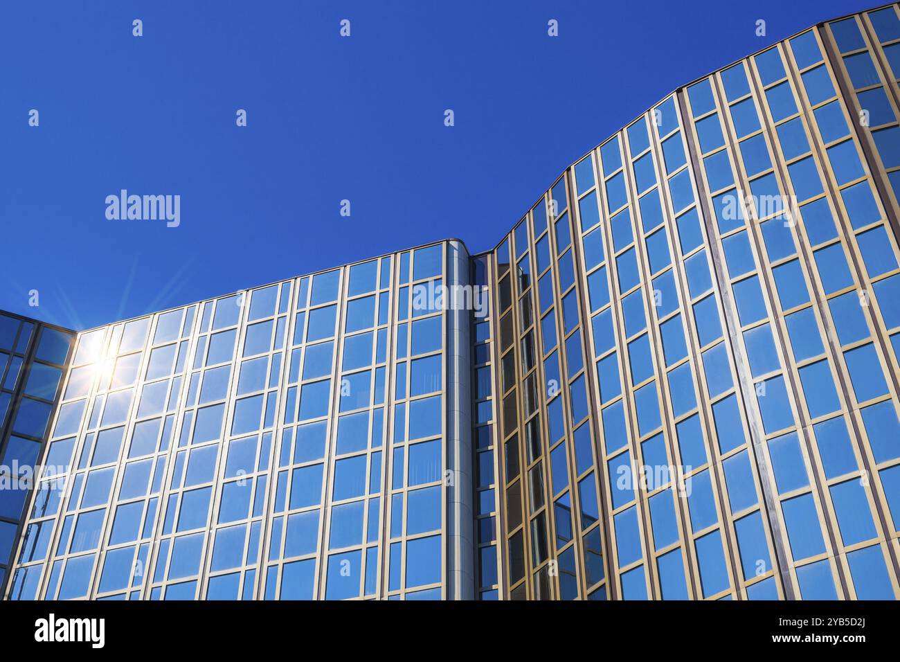 Modern office building with glass facade against a blue sky Stock Photo ...