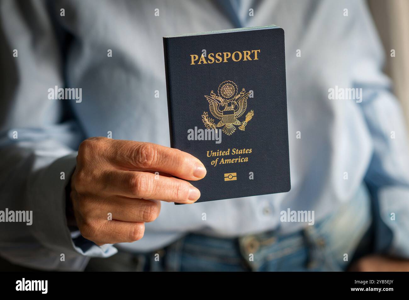 Woman holding a American passport, ready for a trip, capturing the excitement of travel and exploring new countries Stock Photo