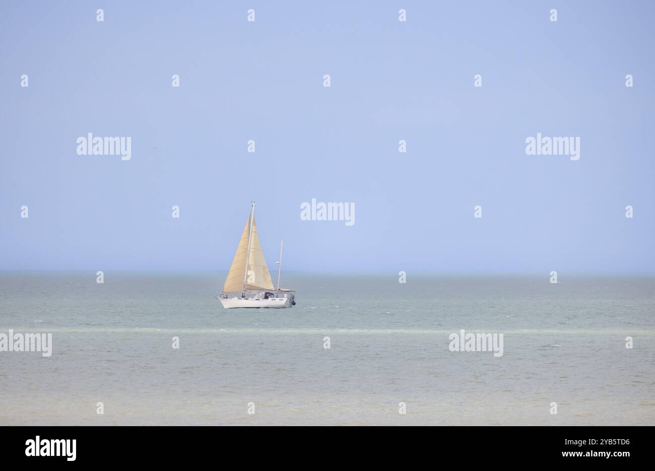 A beautifully tranquil view of a sailboat gliding effortlessly on calm ...