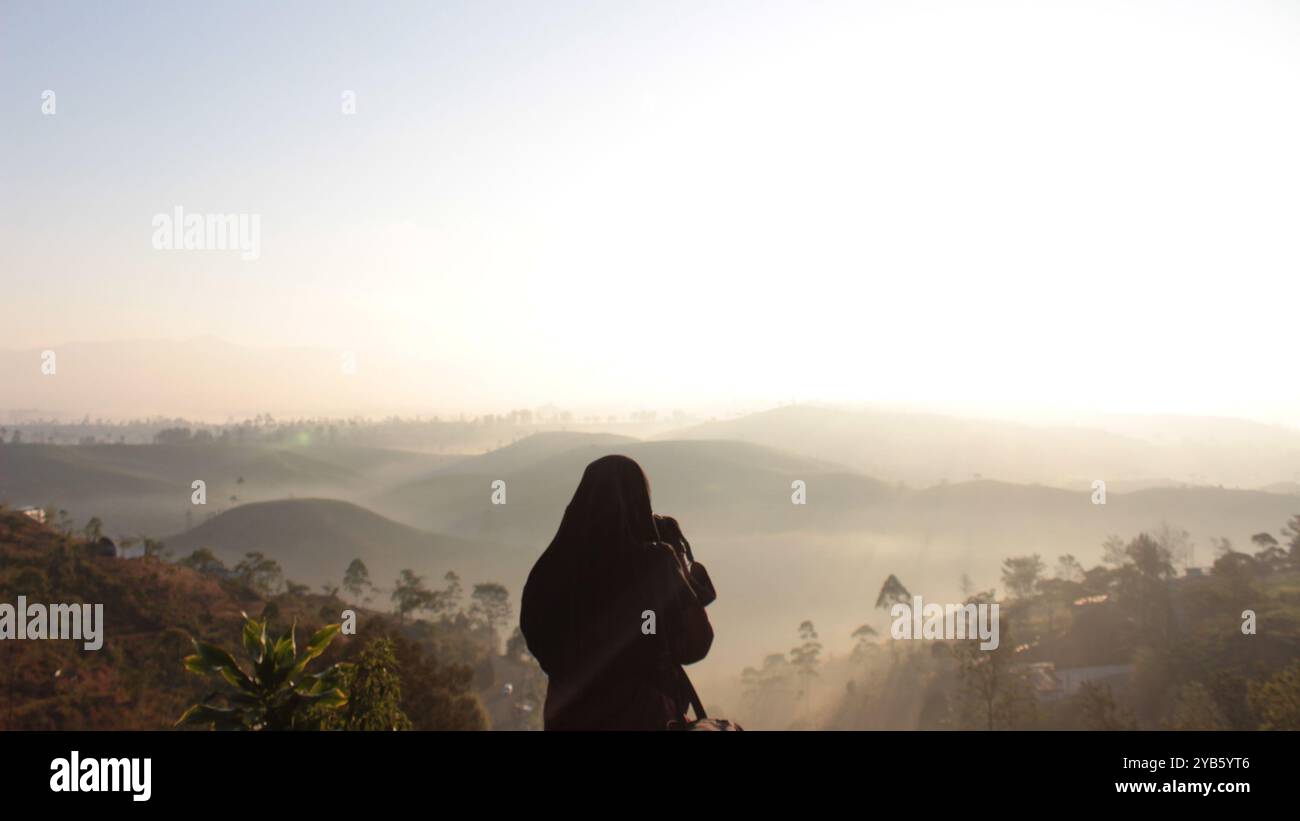 A girl taking a picture of the sunrise Stock Photo - Alamy