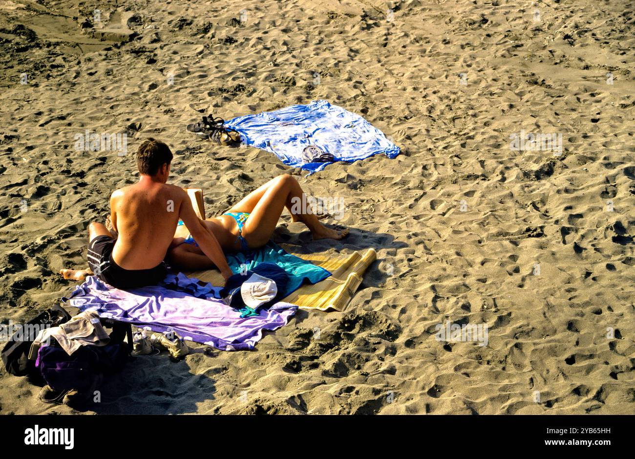 Aerial view of a couple on beach reading a book, Vernazza, Cinque Terre,  Italy Stock Photo