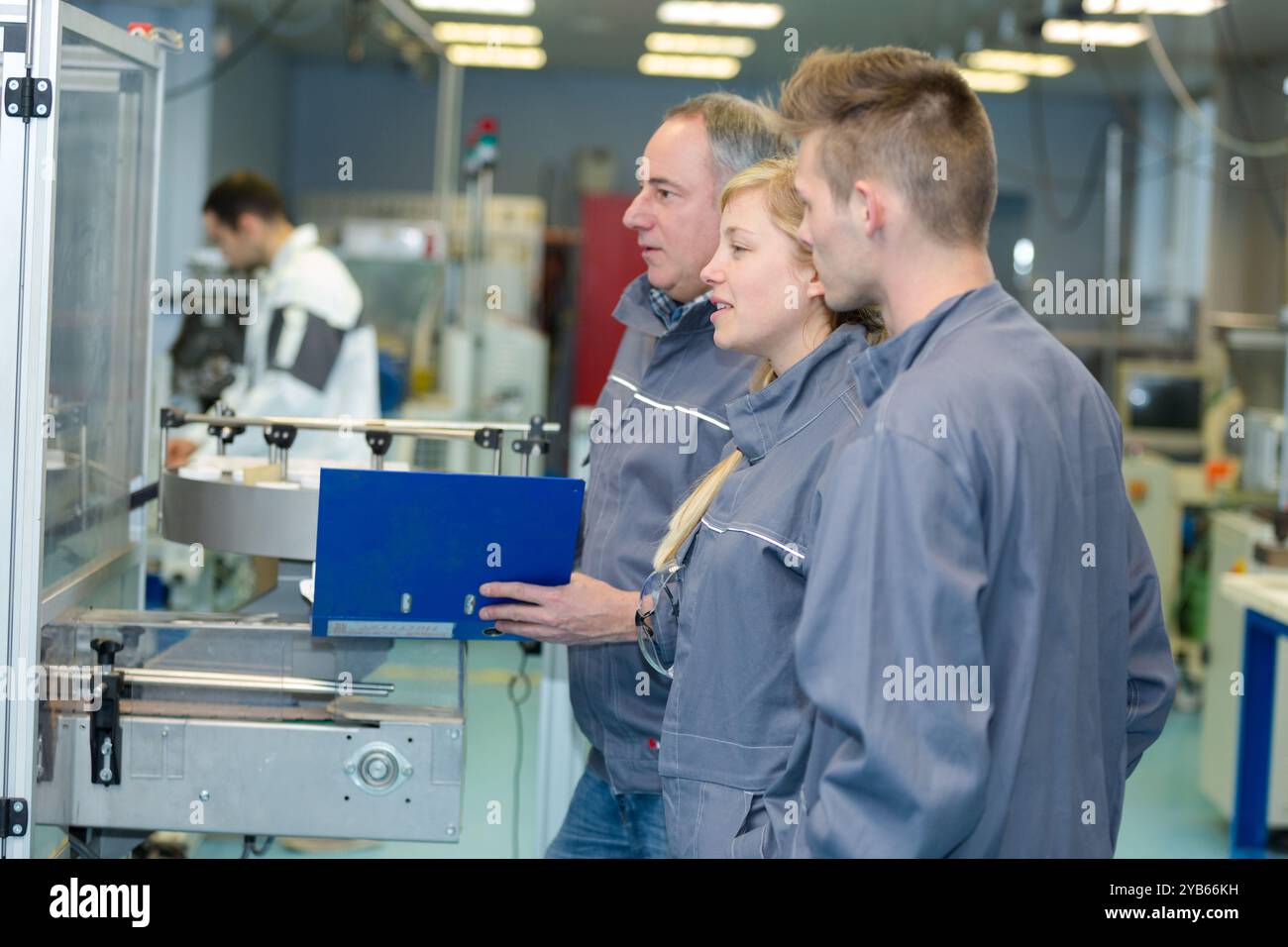 apprentice and engineer using computer controlled cutting machine Stock Photo