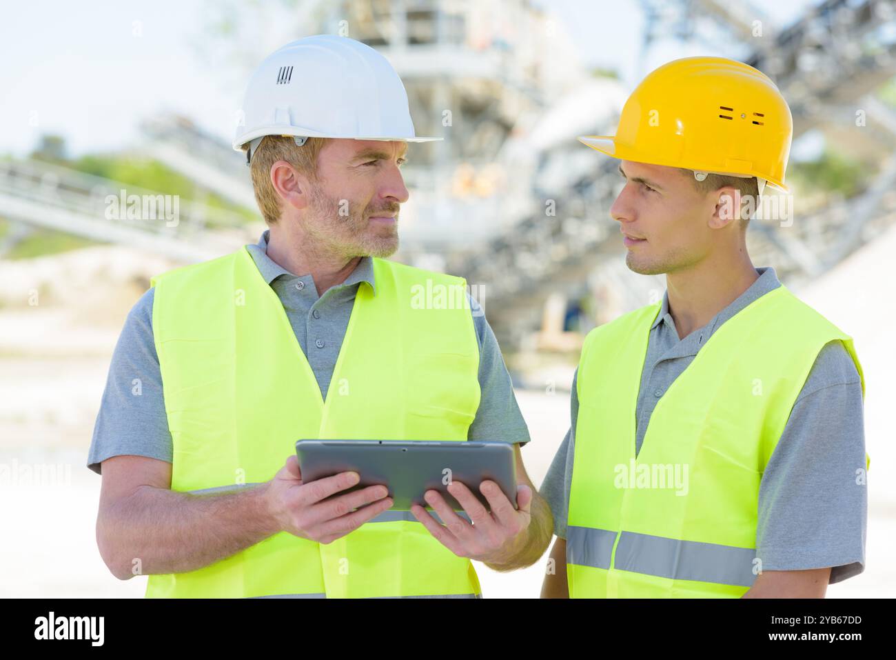 two workers on a construction site using a tablet Stock Photo