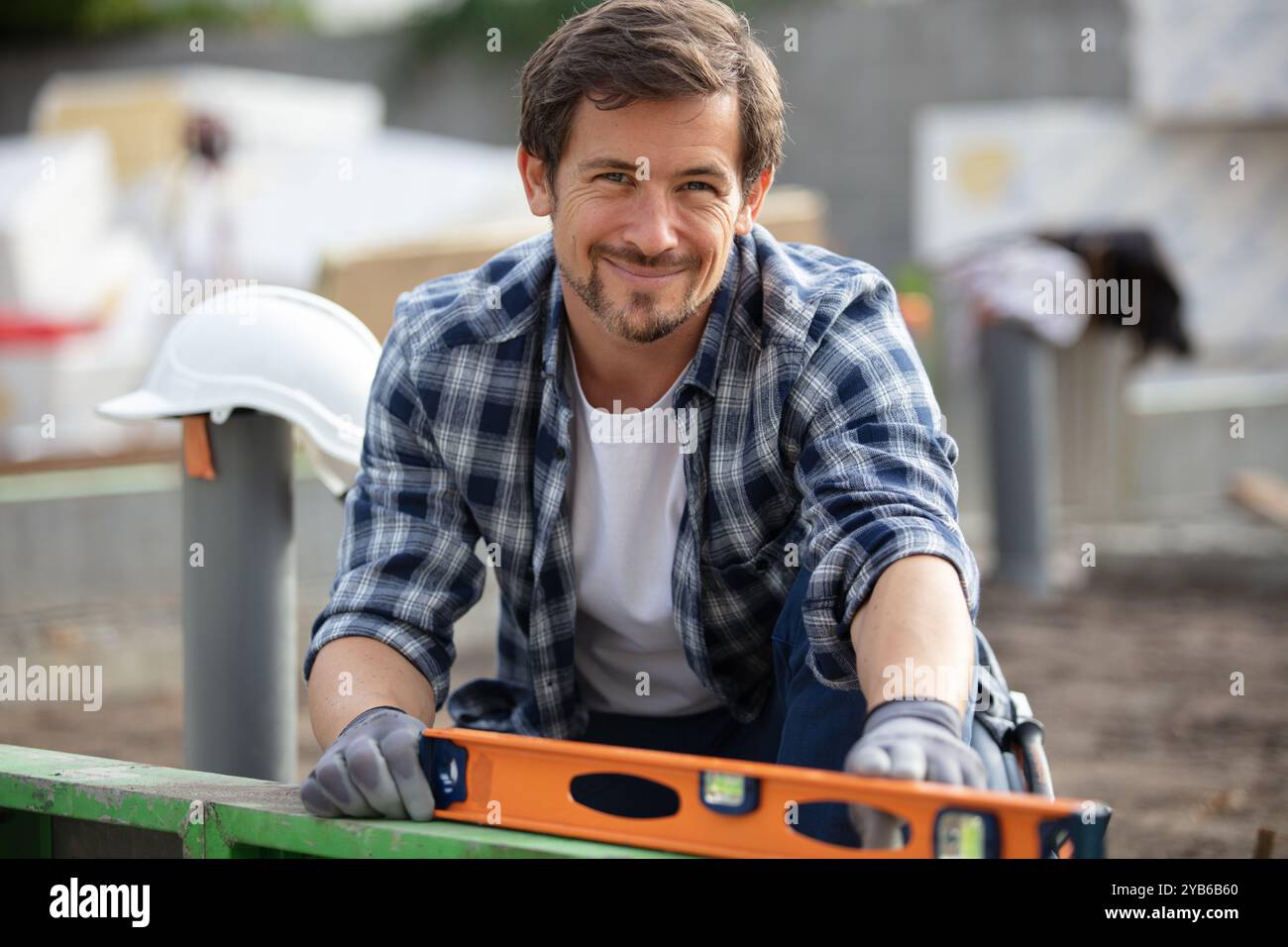 young handyman using spirit level outdoors Stock Photo