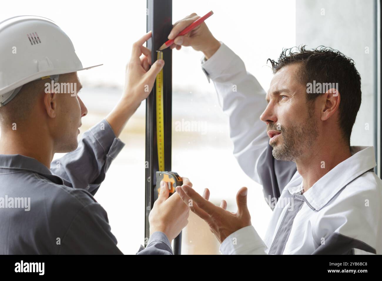 Window Apprentice man and apprentice measuring window Stock Photo - Alamy