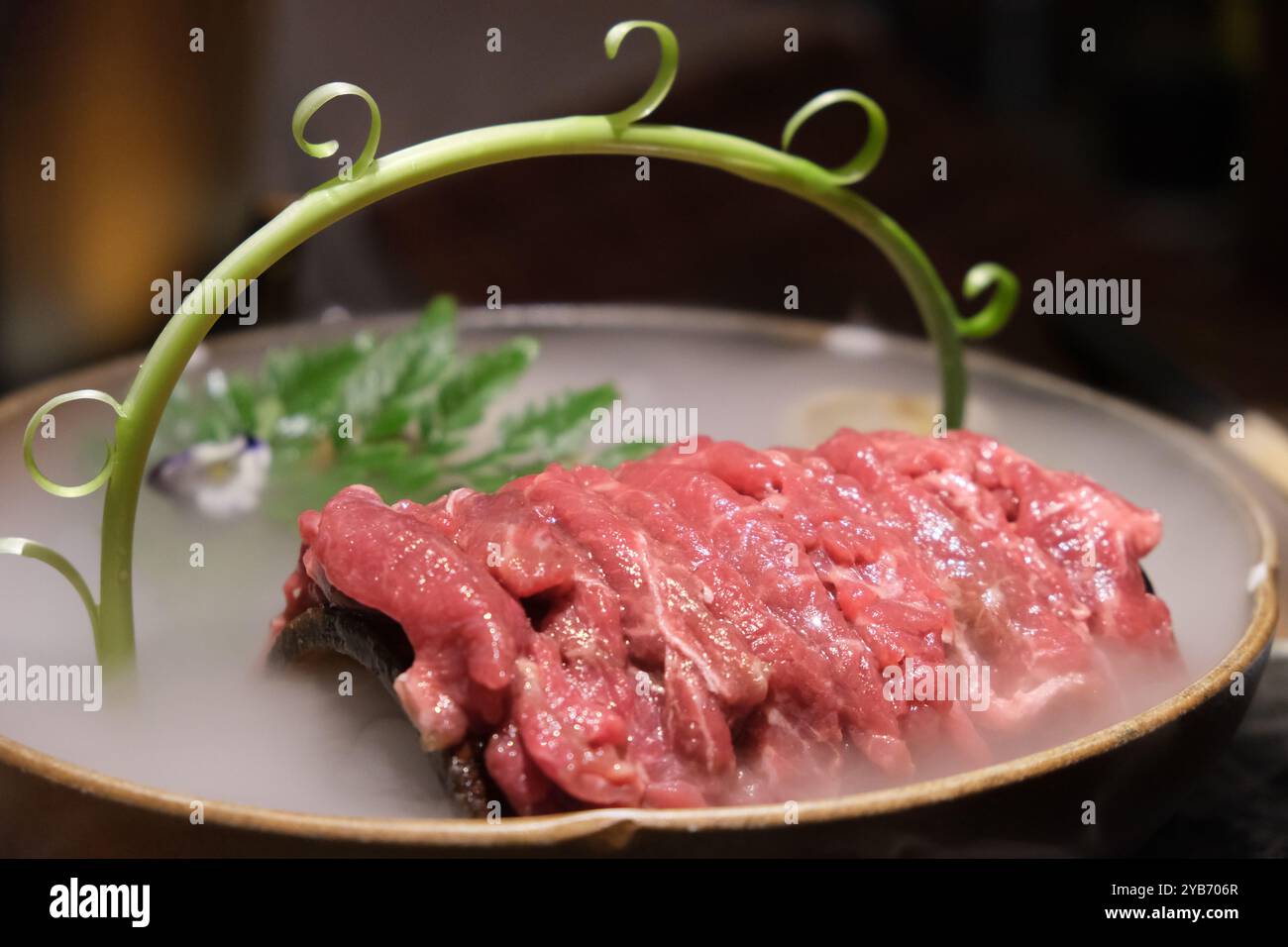 close up sliced raw beef meat in plate with dry ice. Stock Photo