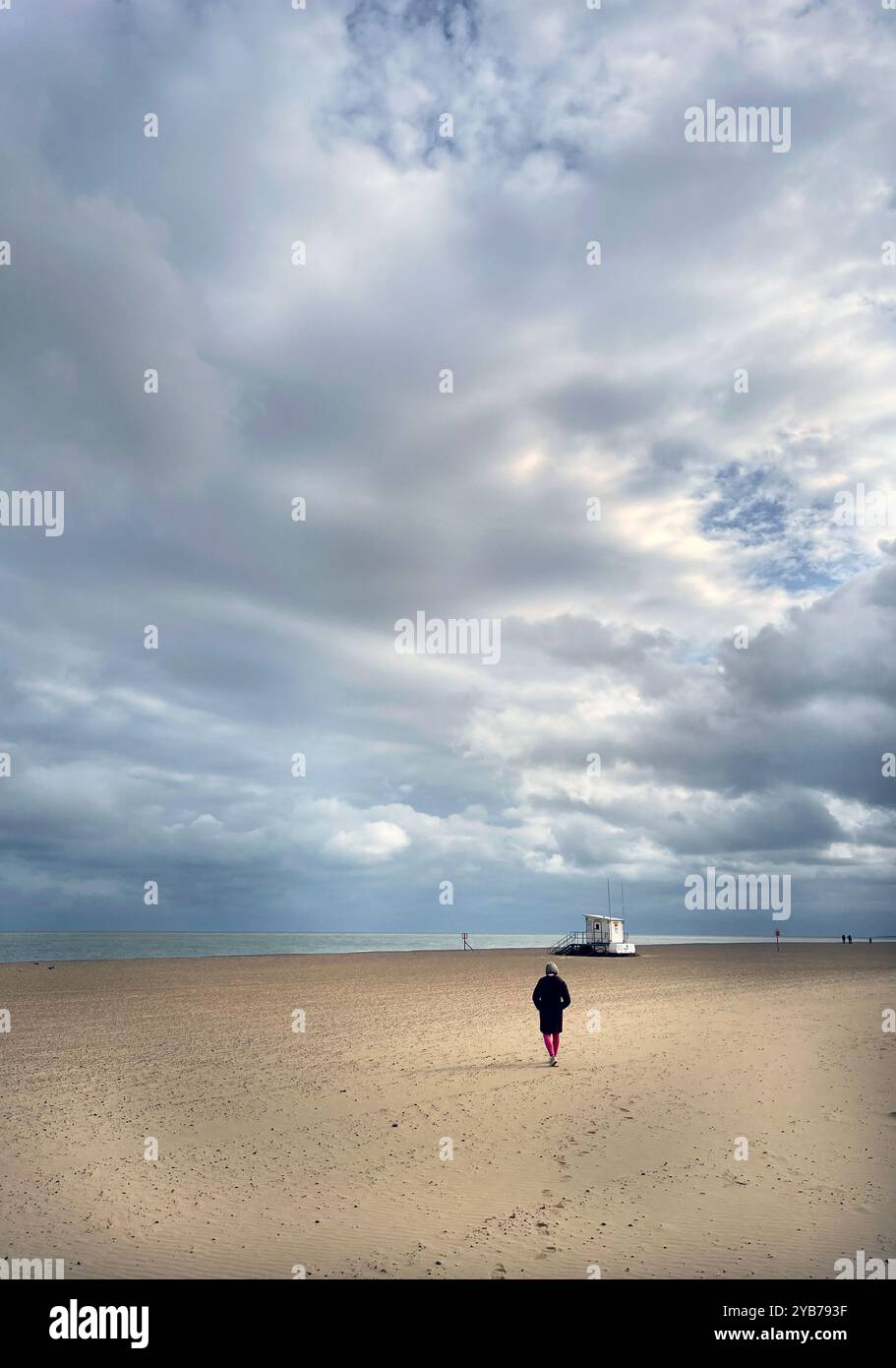 solitary female figure walking on south beach, lowestoft, suffolk, england Stock Photo