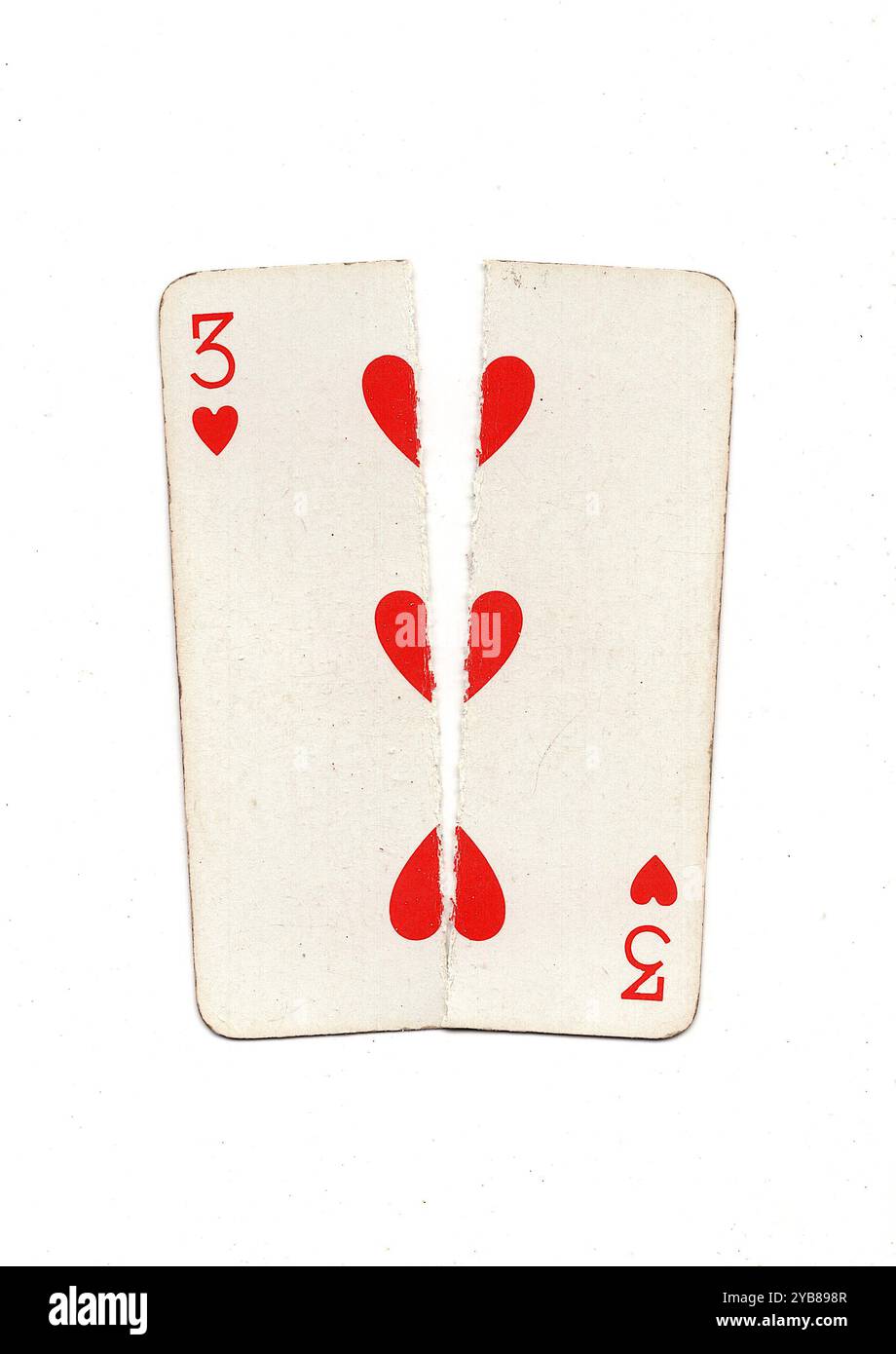 A vintage playing card torn in half from top to bottom on a white ...