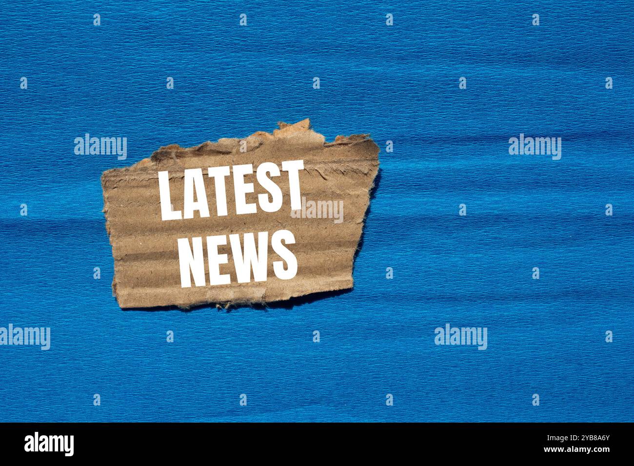 Latest news message written on ripped torn cardboard paper piece with ...
