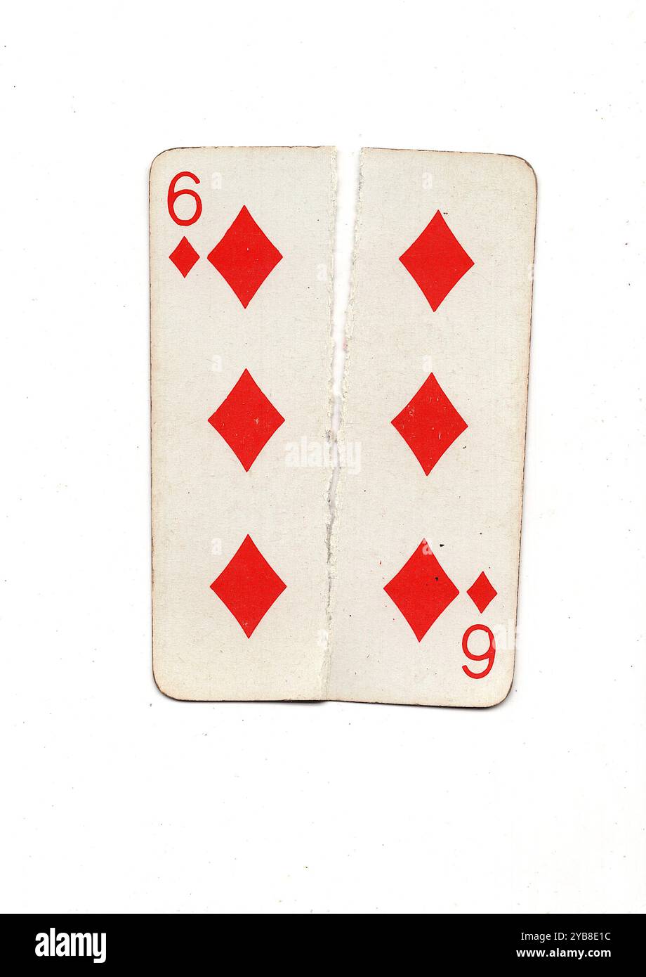 A vintage playing card torn in half from top to bottom on a white ...