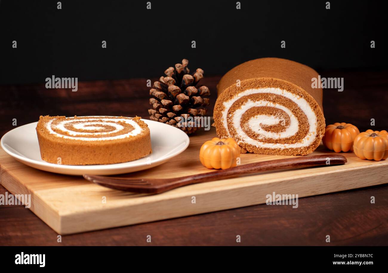 Fall Pumpkin Roll On a Plate With Dark Background Mini Pumpkins and Pinecone Stock Photo