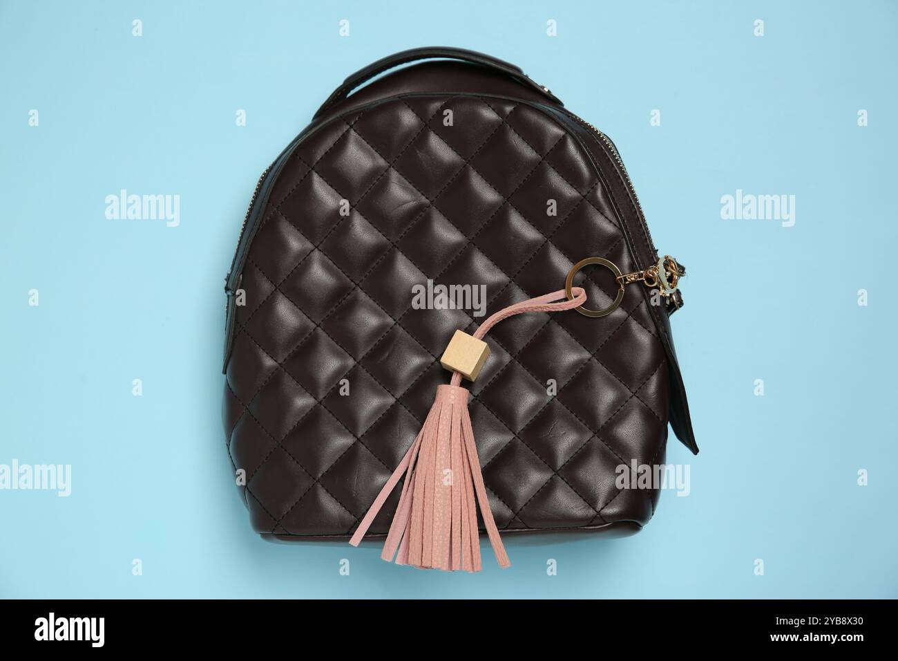 Backpack with pink leather keychain on light blue background, top view Stock Photo