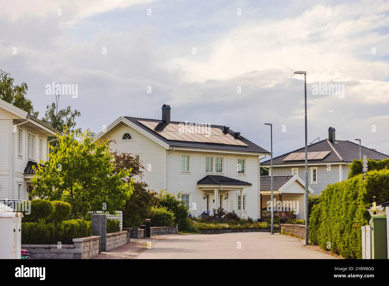 View of Modern villas with solar panels on roofs in suburban residential area ...