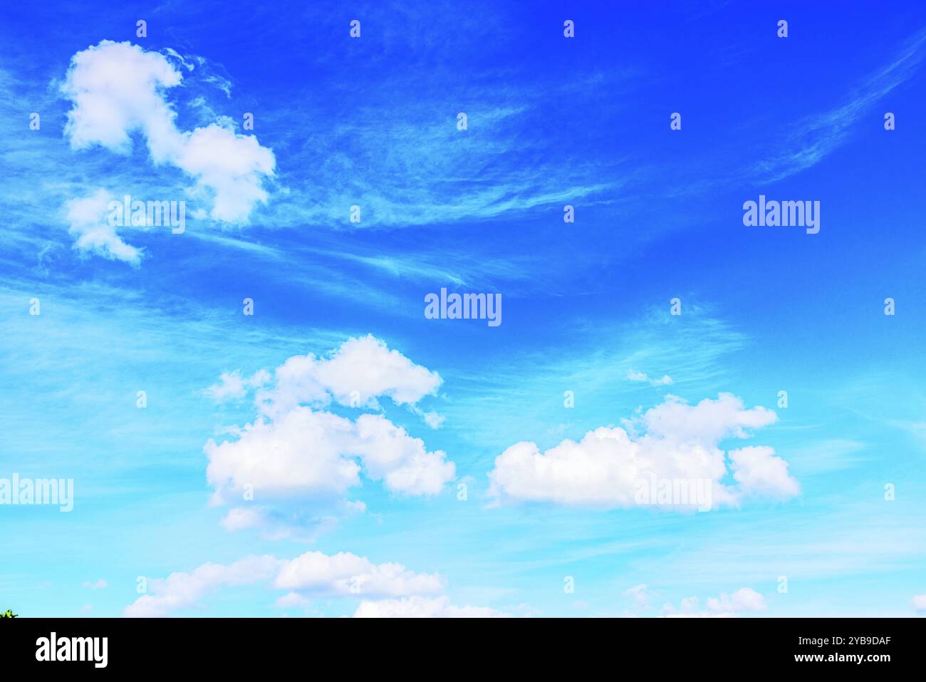 Clear blue sky with soft white clouds on a bright sunny day Stock Photo ...
