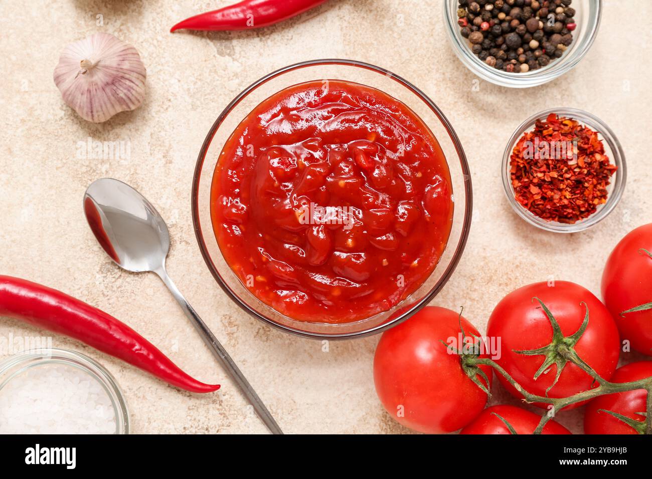 Glass bowl of chili sauce and different ingredients on white background ...