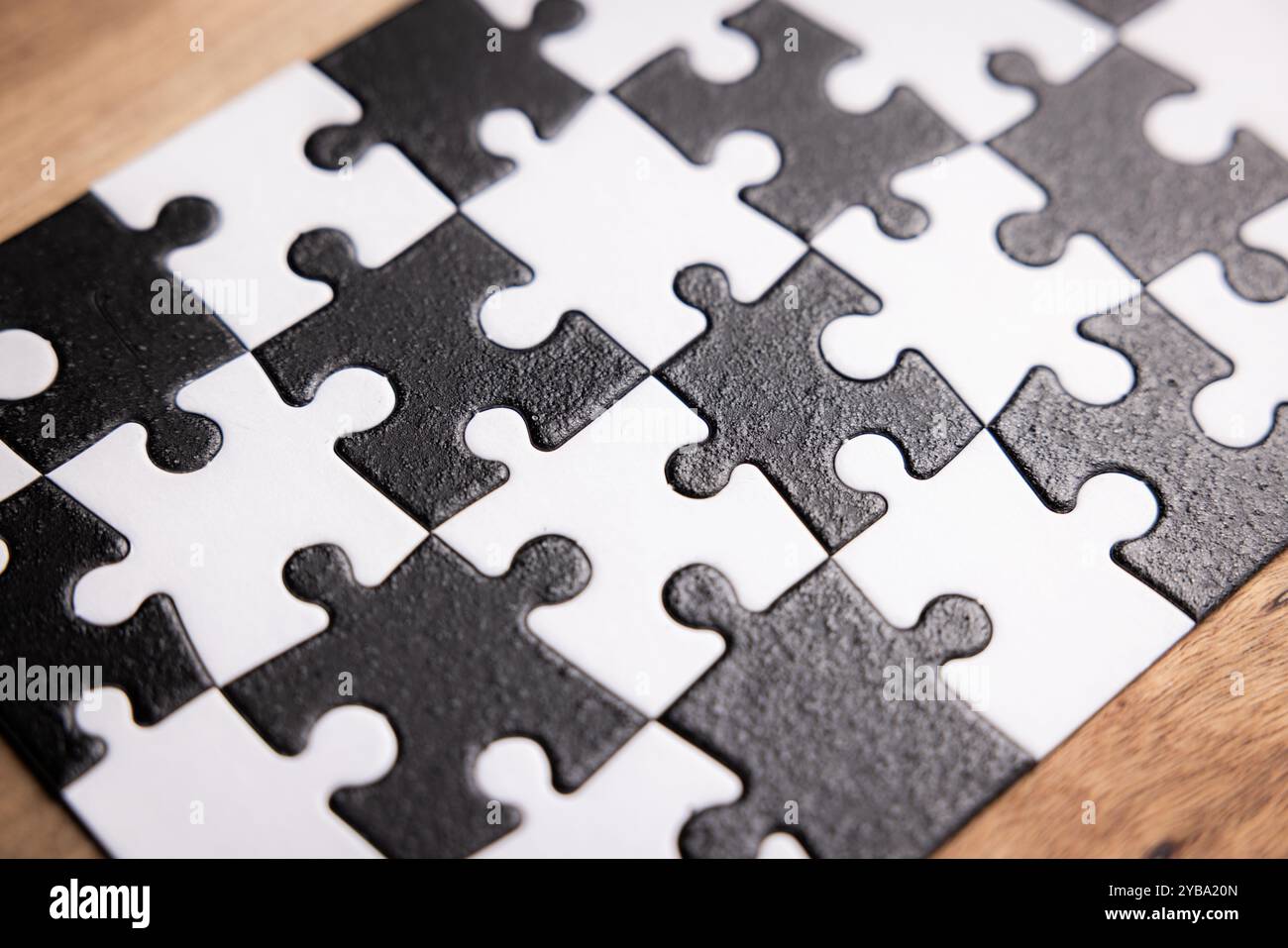A jigsaw puzzle with black and white pieces. The puzzle is made up of ...