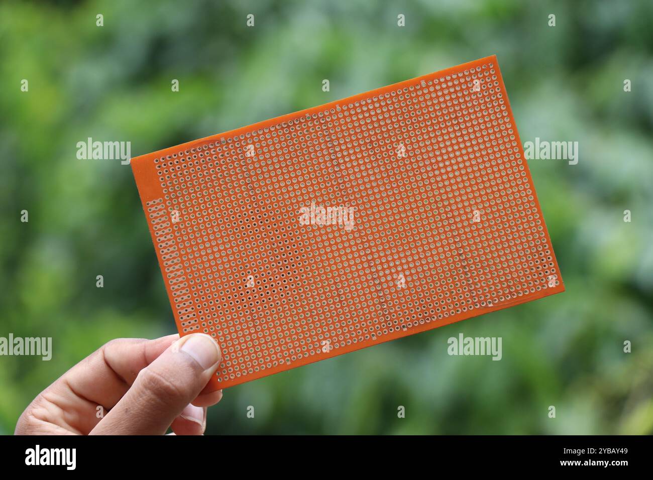 Universal double sided printed circuit board or PCB for prototyping electronics project held in the hand Stock Photo