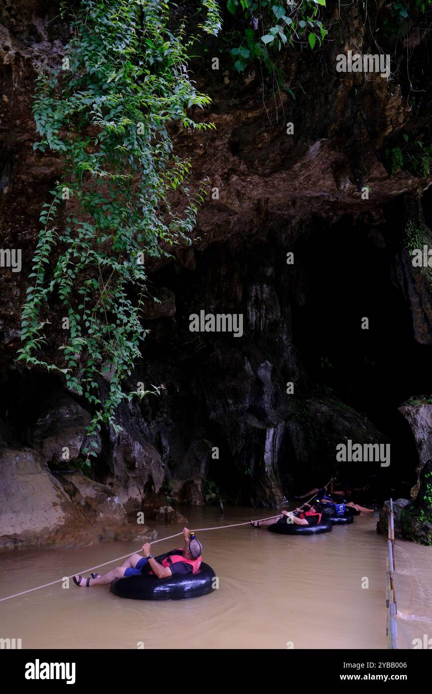 Tourists following a rope tubing into the Tham Nam Water Cave.Vang ...