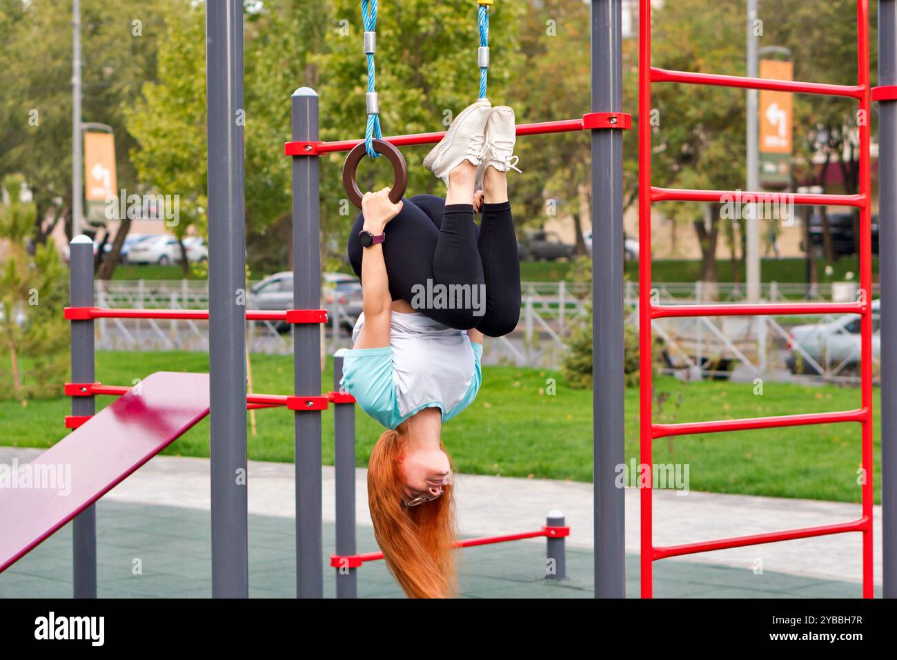 Woman hanging from bar upside down hi-res stock photography and images ...