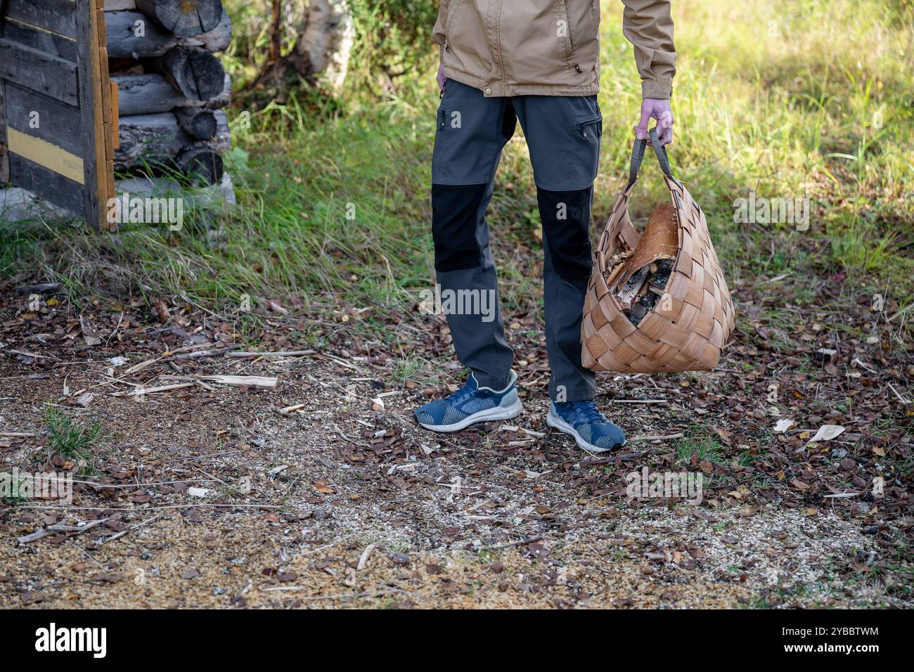 Man with firewood in basket Stock Photo