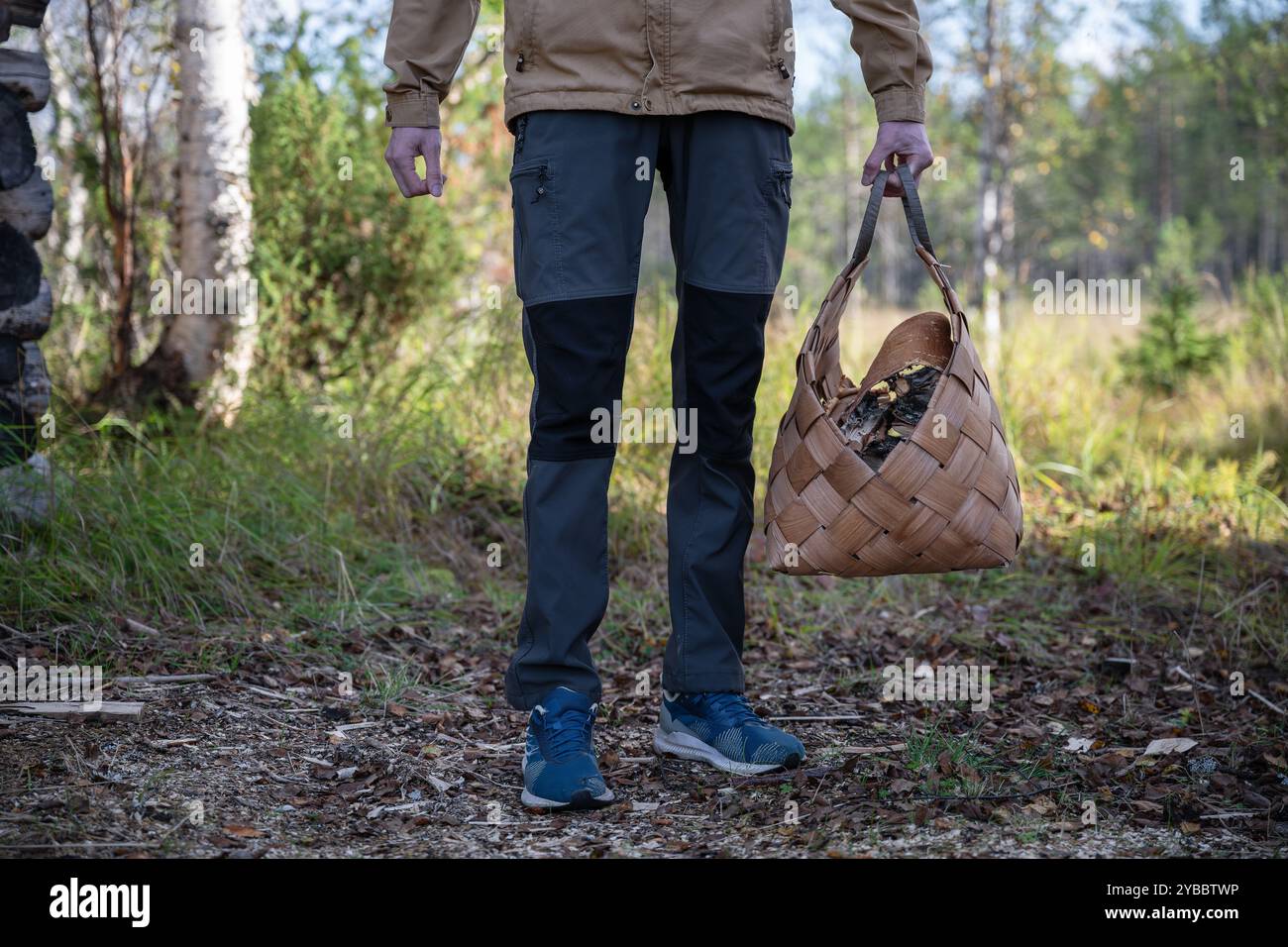 Man with firewood in basket Stock Photo