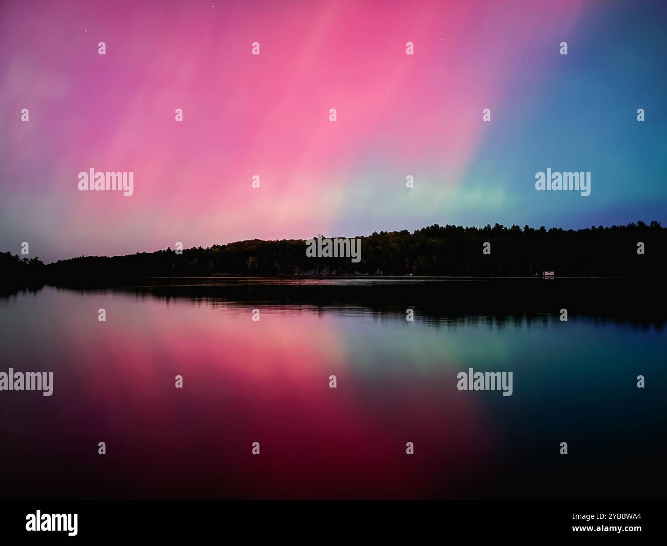 Colorful Aurora Borealis northern lights in sky over lake in Canada ...